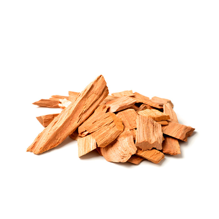 A pile of Mysore sandalwood chips with a light brown hue and rough, natural texture, displayed against a white background